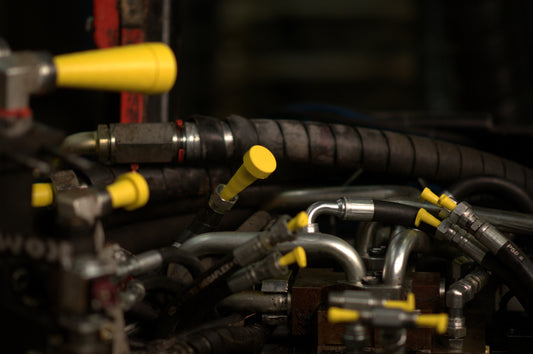 Full range of Yelloc plugs (Micro to XL) sealing a hydraulic unit during repair work.